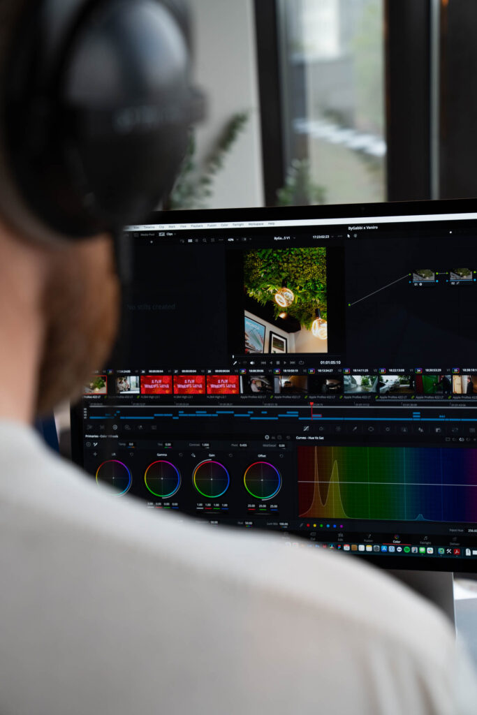 Bilde av en DJI drone som filmer med en mann i forgrunn