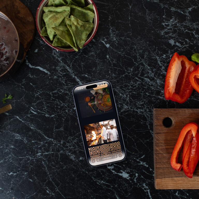 Bilde av en iphone som ligger på en kjøkkenbenk med paprika på siden